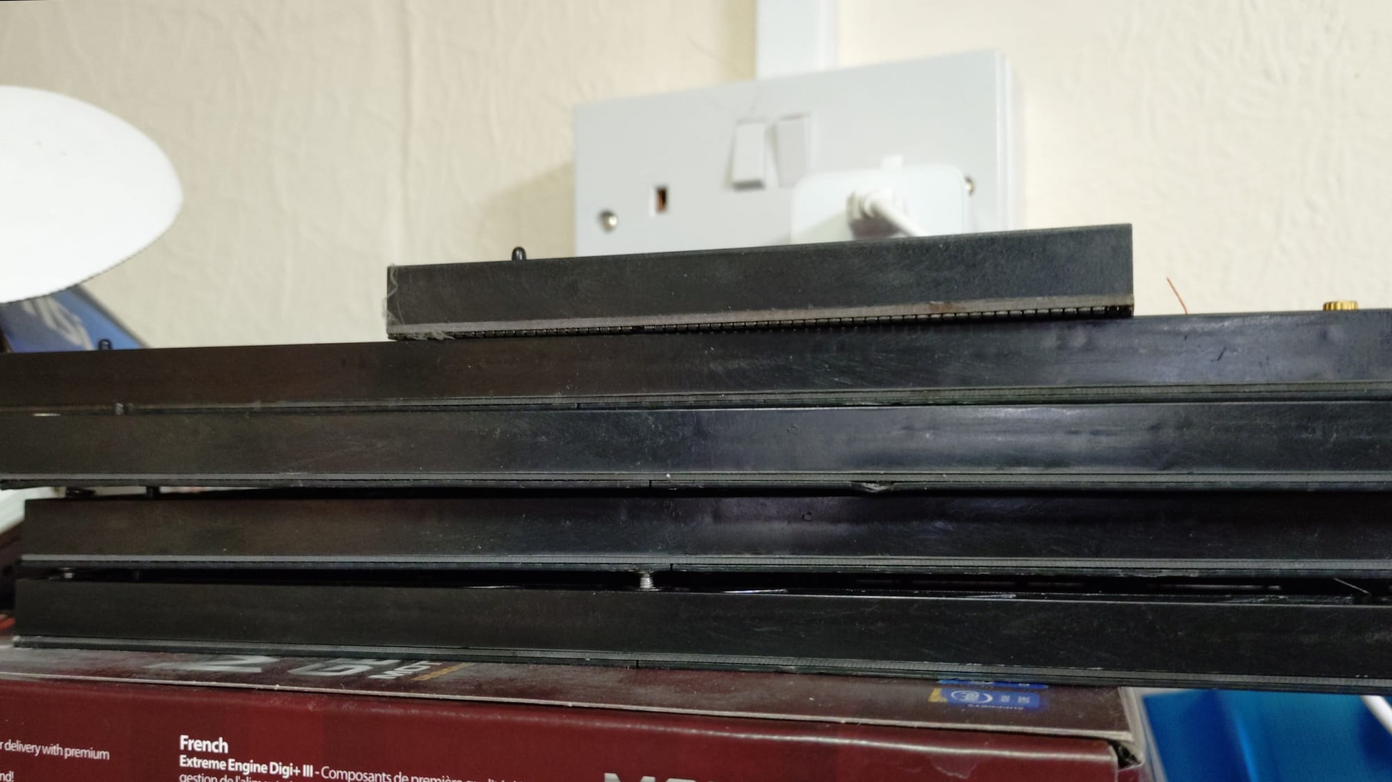4 longer and one shorter led panels stacked on top of a motherboard box, in front of a double UK plug socket
